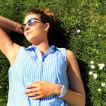 woman with sunglasses lying in the sun on the grass